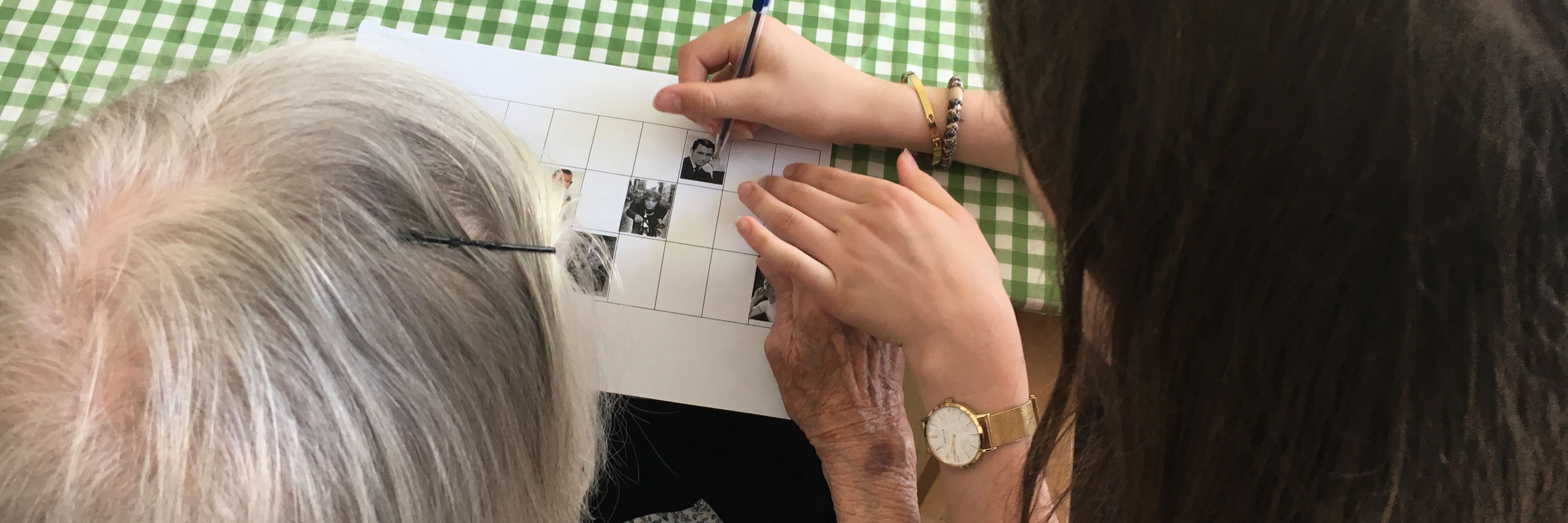 En medarbejder hjælper en beboer med at spille banko.